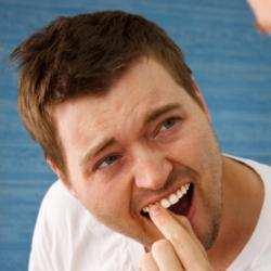 Junger Mann testet Halt der Zähne - Parodontitis?