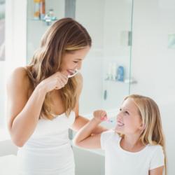 Mutter und Tochter putzen ihre Zähne