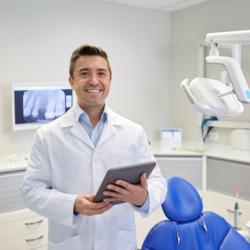 Zahnarzt in der Praxis mit Anamnesebogen in der Hand