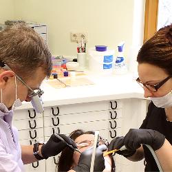 Zahnarzt und Helferin bei der Behandlung